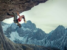 Lily James scaling the rockface in CLIFFHANGER